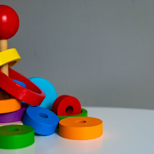 Child playing with rainbow stacking tower